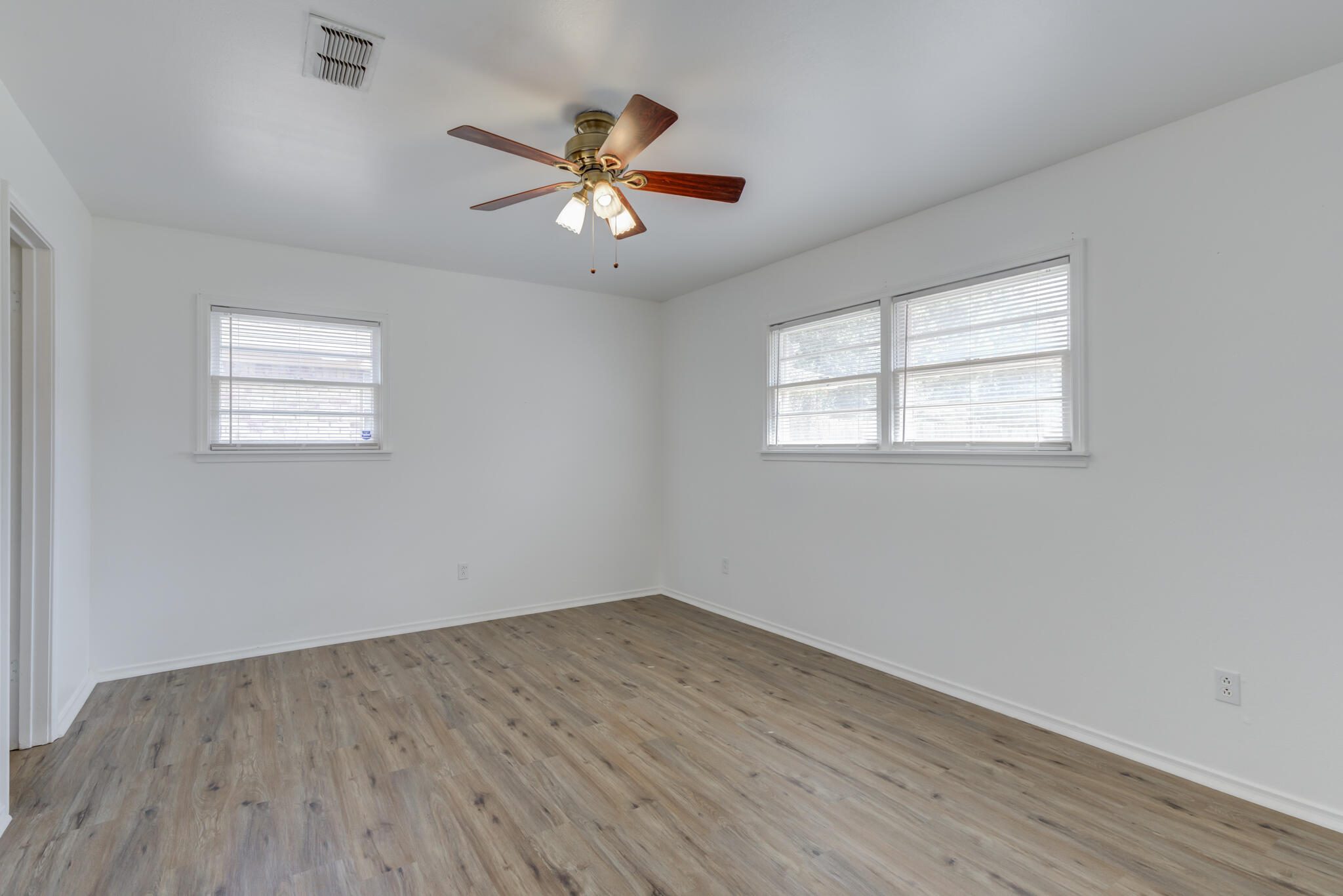 3023 66th Street Lubbock, TX 79413 - Photo 32 of 40 a view of empty room with wooden floor and fan