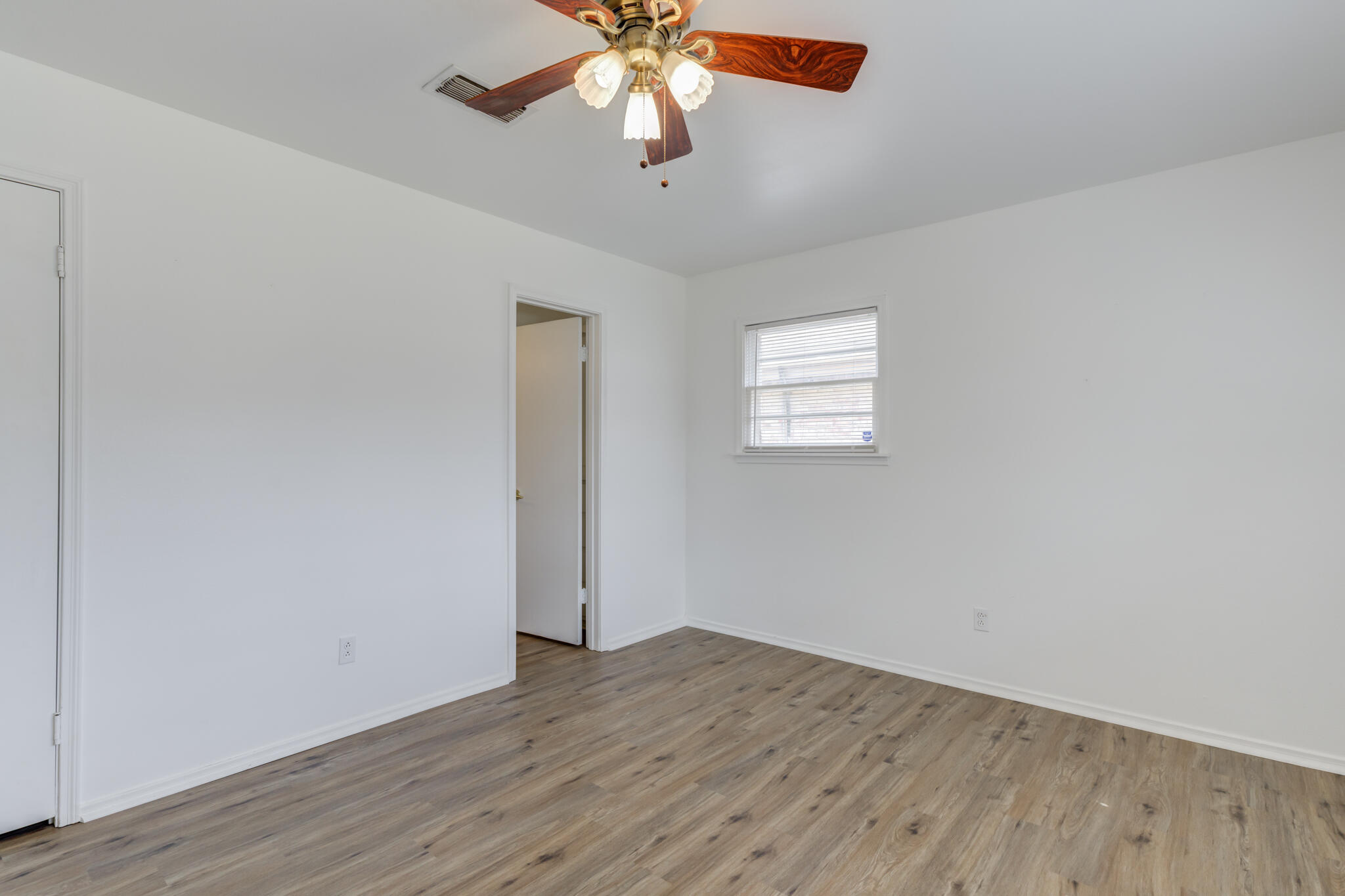 3023 66th Street Lubbock, TX 79413 - Photo 33 of 40 an empty room with wooden floor chandelier fan and windows