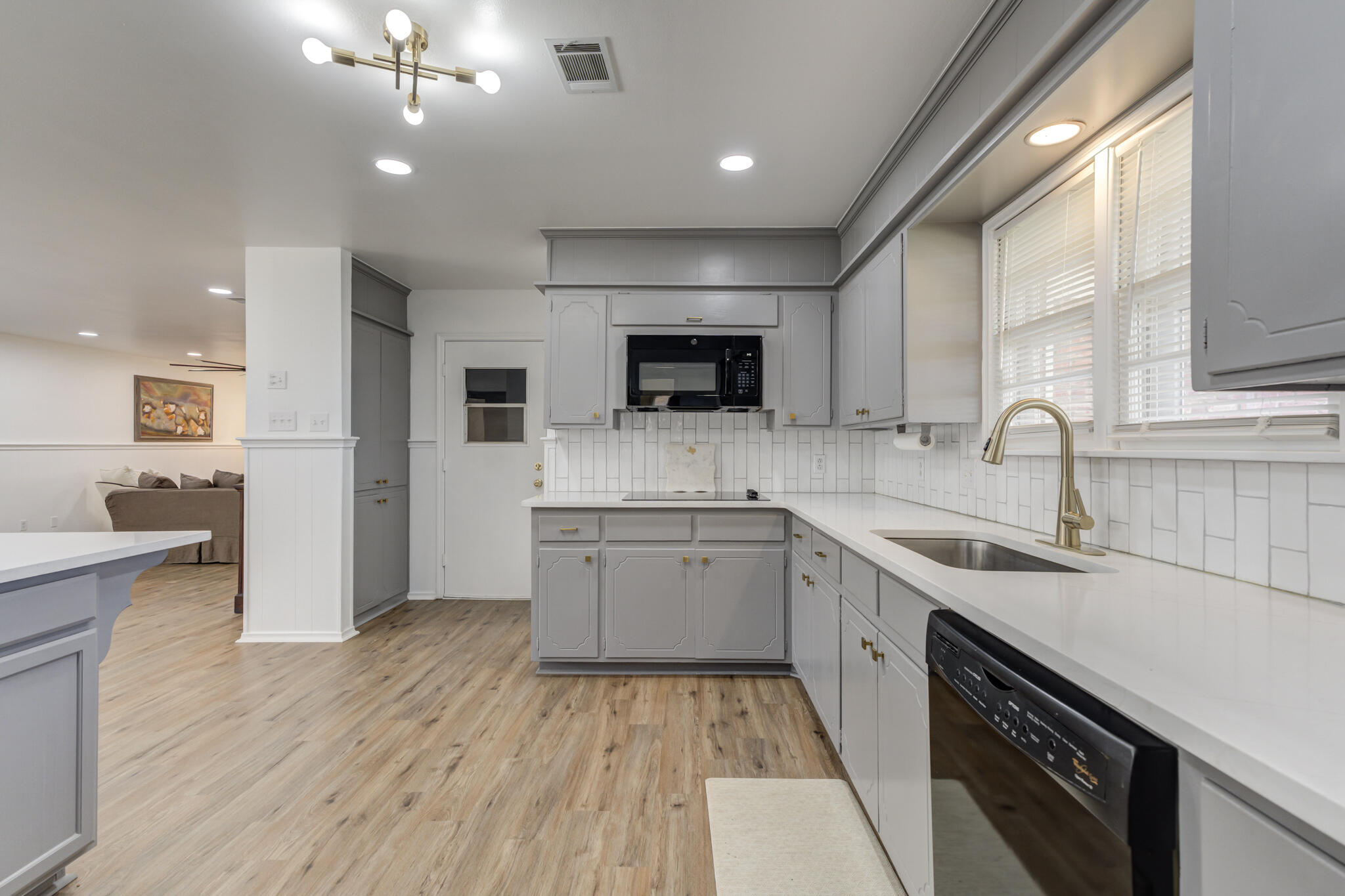 3023 66th Street Lubbock, TX 79413 - Photo 5 of 40 a kitchen with a sink window and cabinets