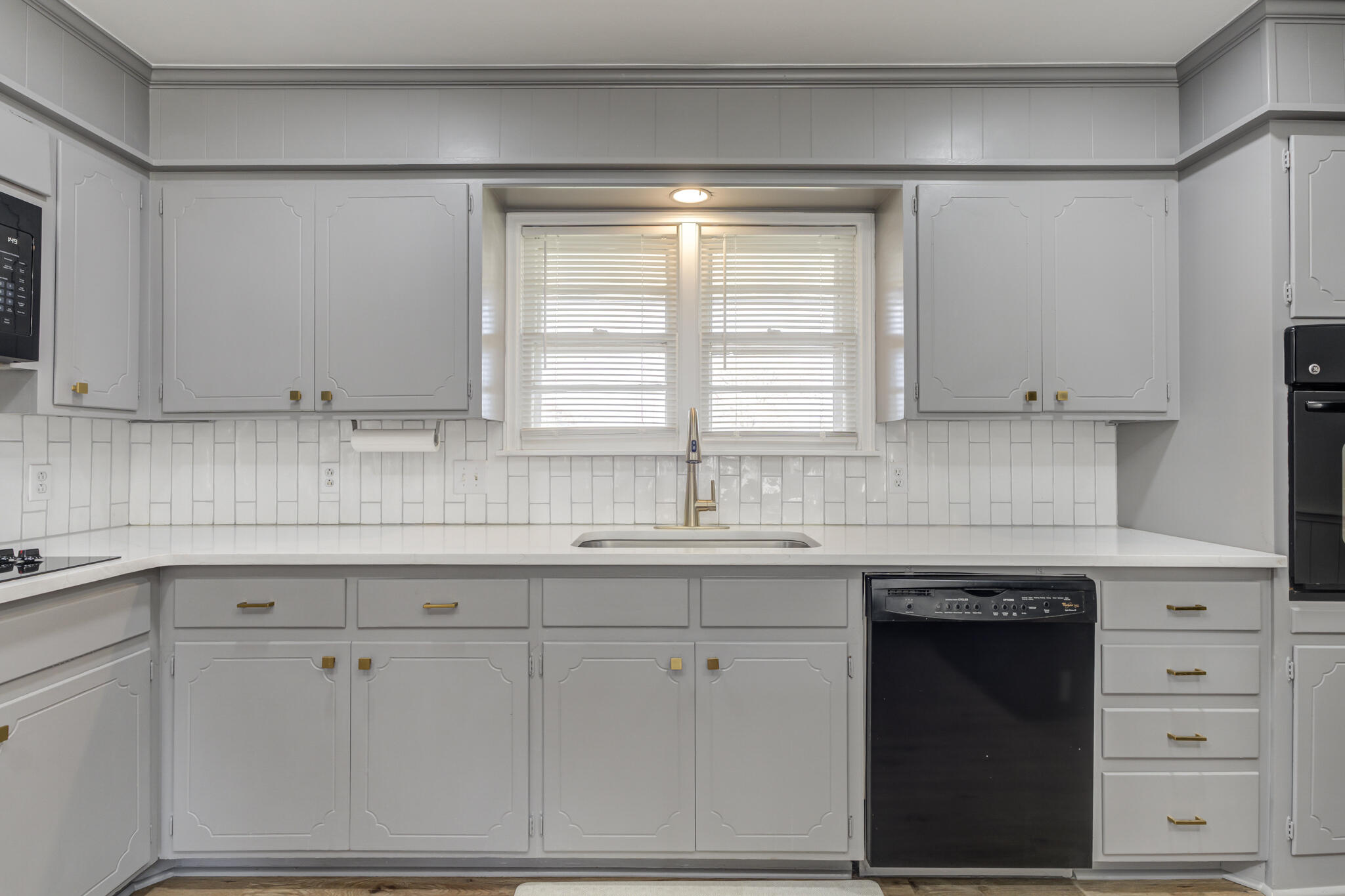 3023 66th Street Lubbock, TX 79413 - Photo 8 of 40 a kitchen with white cabinets and a window