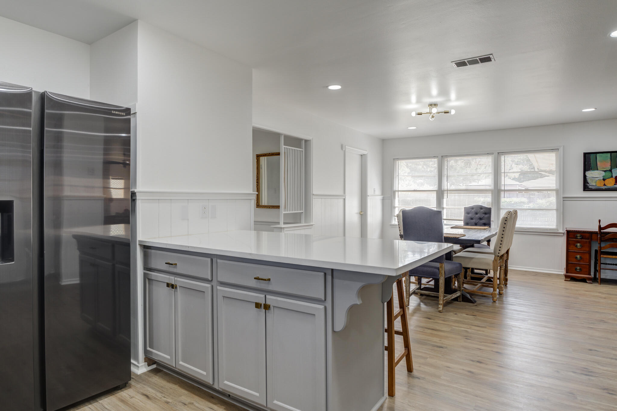 3023 66th Street Lubbock, TX 79413 - Photo 10 of 40 a kitchen with stainless steel appliances granite countertop a table chairs refrigerator and sink