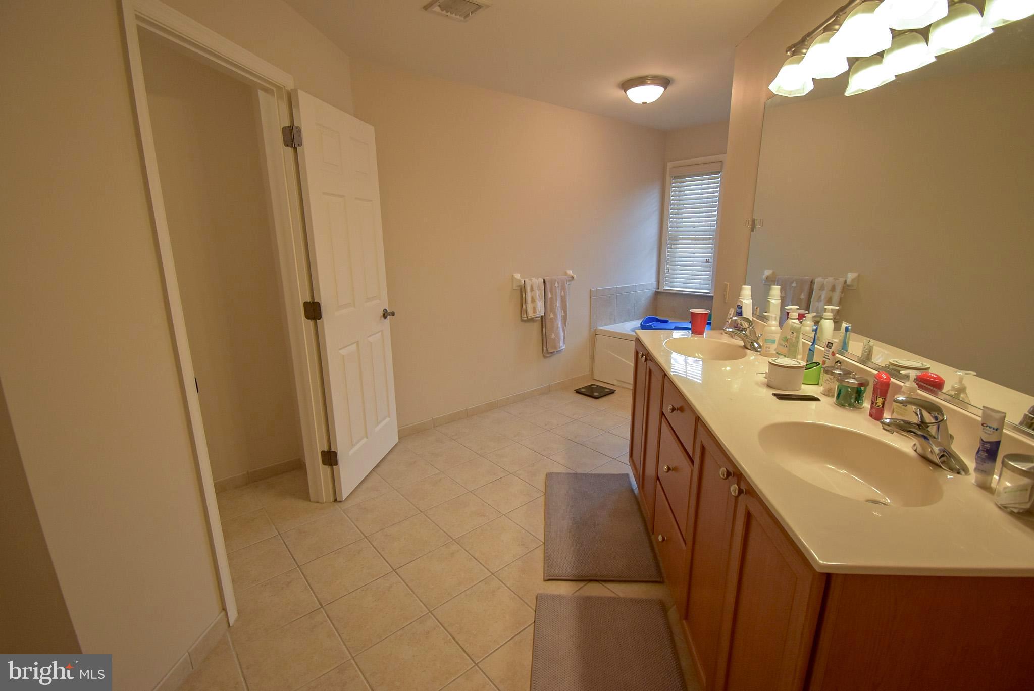 586 Wharton Boulevard Exton, PA 19341 - Photo 17 of 28 a en suite bathroom with a sink a mirror and a shower