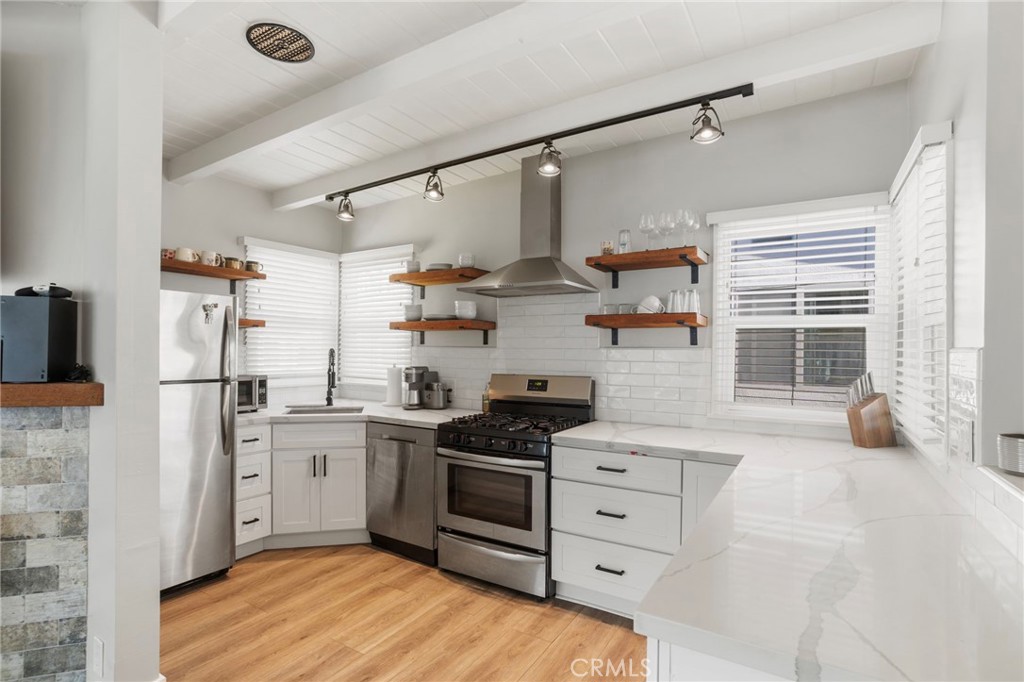 27 66th Place Long Beach, CA 90803 - Photo 12 of 56 a kitchen with stainless steel appliances a stove a sink and a refrigerator