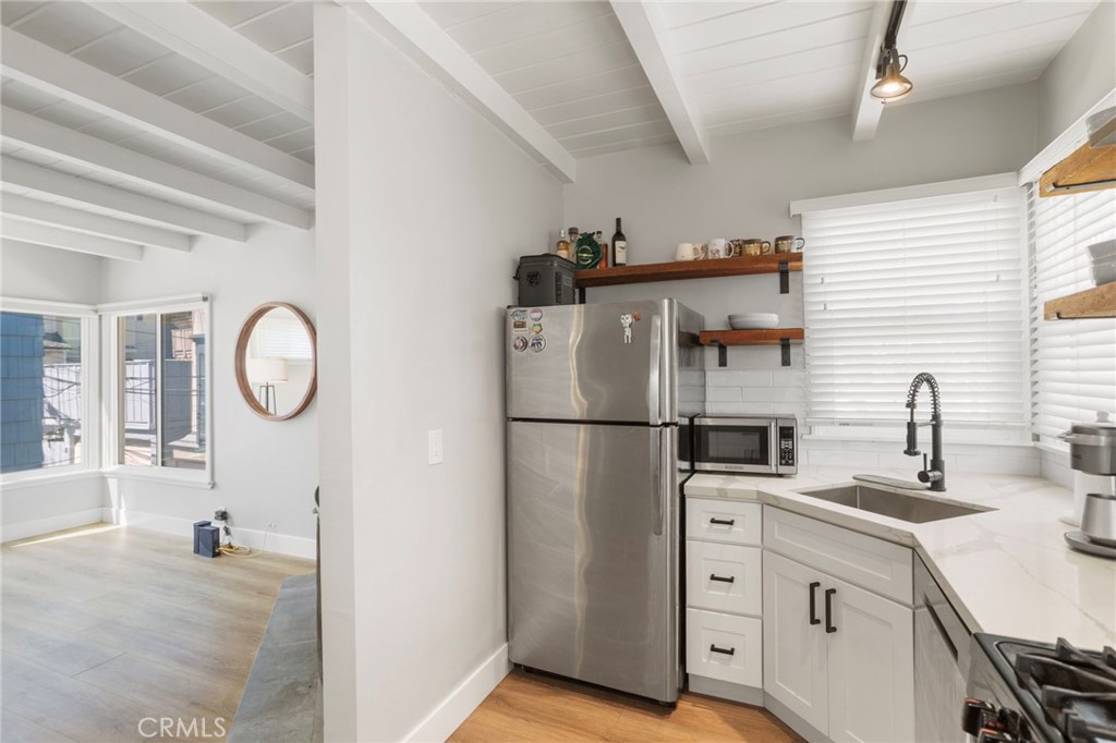27 66th Place Long Beach, CA 90803 - Photo 14 of 56 a kitchen with cabinets and a refrigerator
