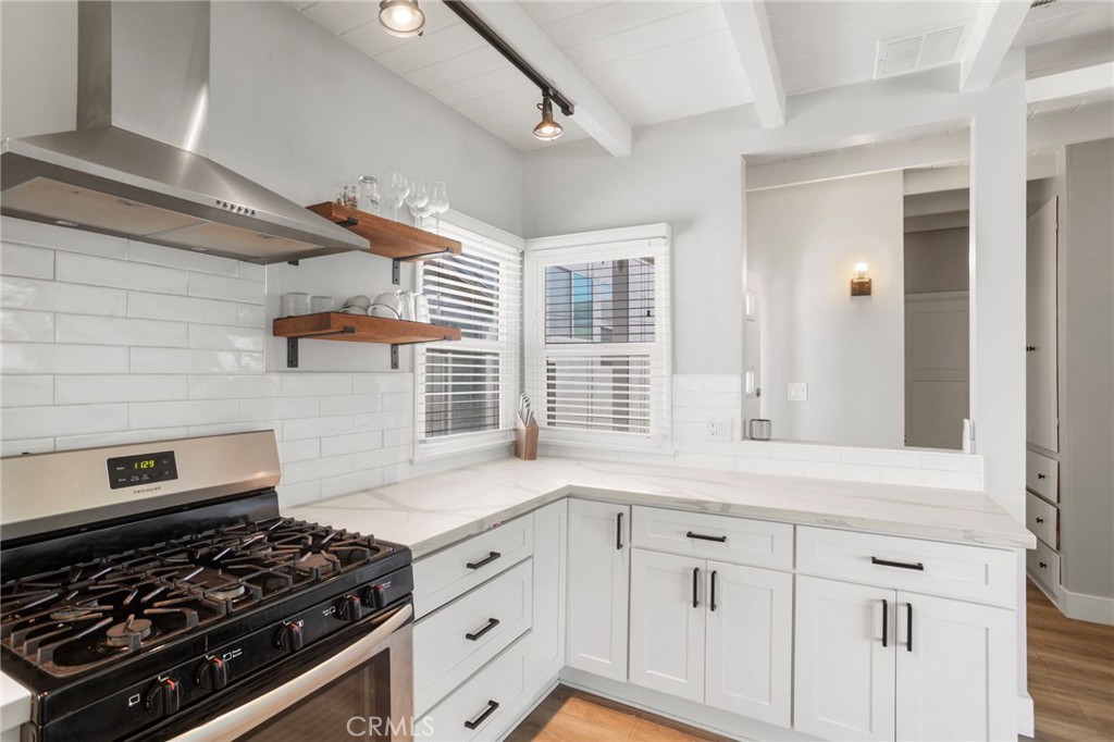 27 66th Place Long Beach, CA 90803 - Photo 15 of 56 a kitchen with white cabinets and a stove top oven