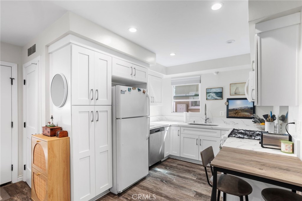 27 66th Place Long Beach, CA 90803 - Photo 20 of 56 a kitchen with cabinets a refrigerator and a stove top oven