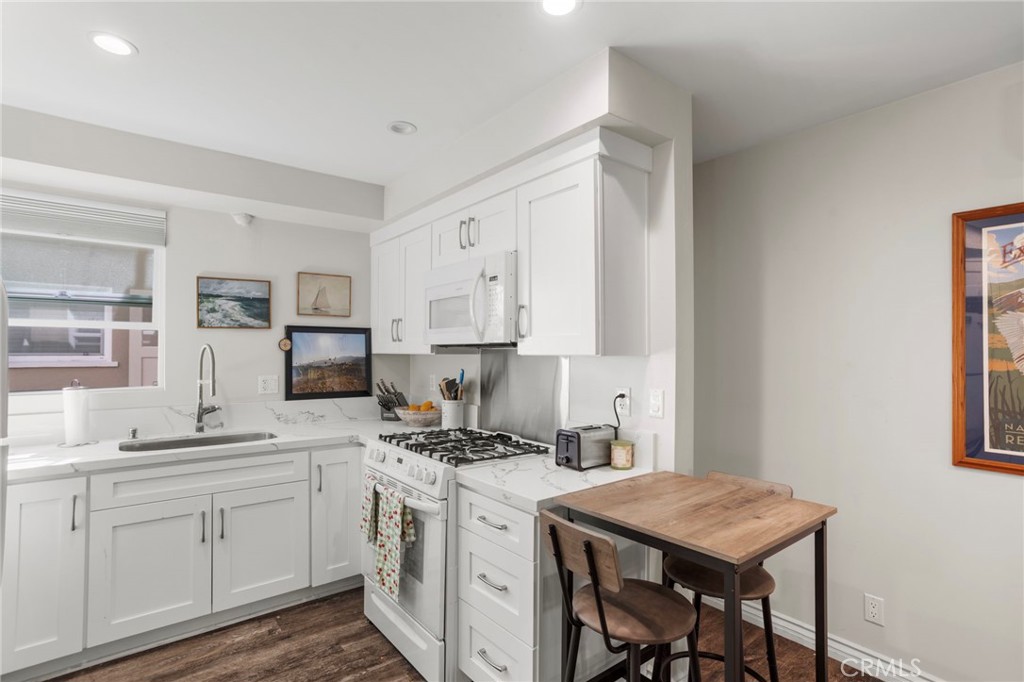 27 66th Place Long Beach, CA 90803 - Photo 21 of 56 a kitchen with a sink stove and cabinets