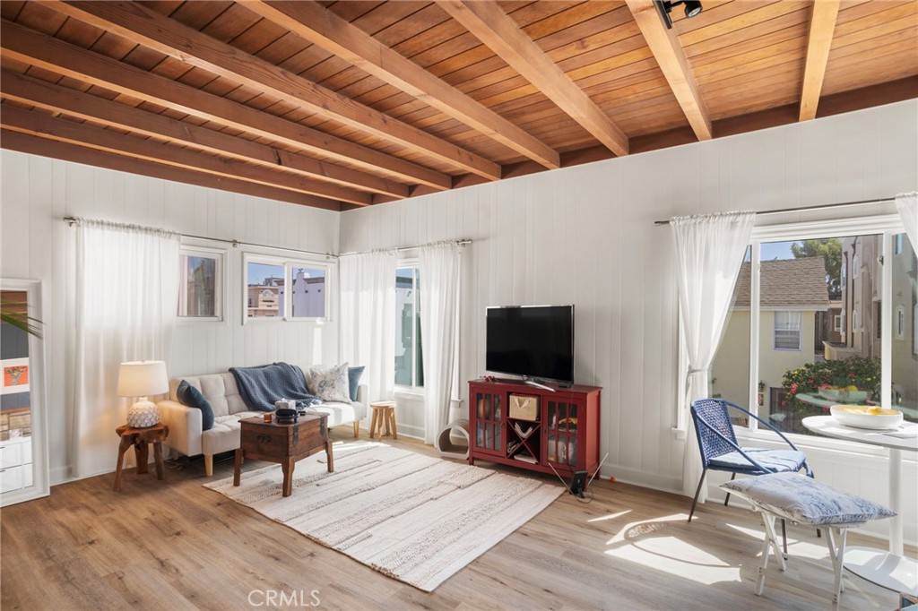 27 66th Place Long Beach, CA 90803 - Photo 24 of 56 a living room with furniture a flat screen tv and a floor to ceiling window