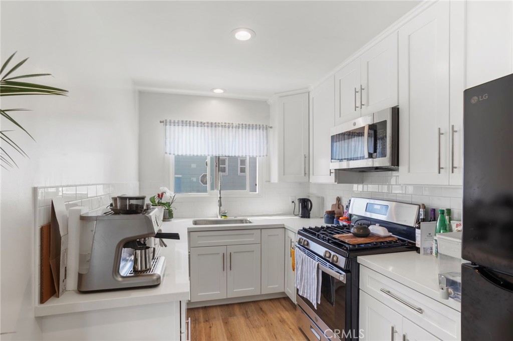 27 66th Place Long Beach, CA 90803 - Photo 28 of 56 a kitchen with stainless steel appliances granite countertop a sink stove refrigerator and cabinets