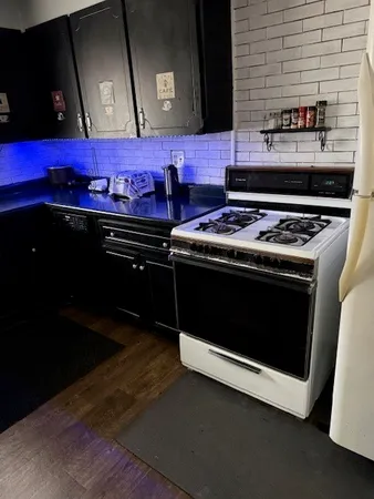 a stove top oven sitting inside of a kitchen