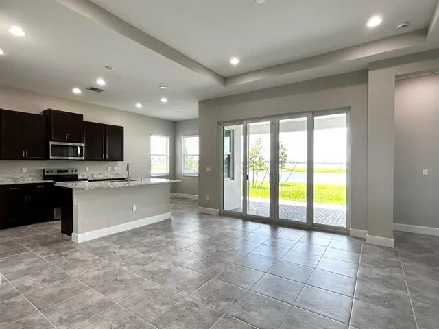 a large kitchen with a large counter top stainless steel appliances and cabinets