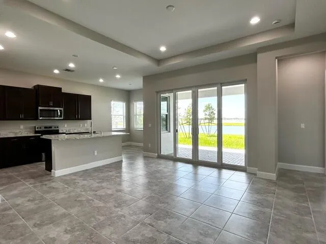 a large kitchen with granite countertop a large counter top stainless steel appliances and cabinets