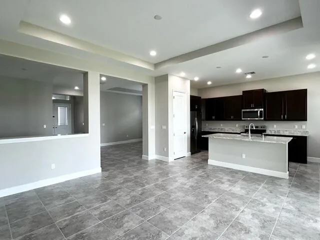 a large kitchen with stainless steel appliances kitchen island granite countertop a large counter top and a stove top oven