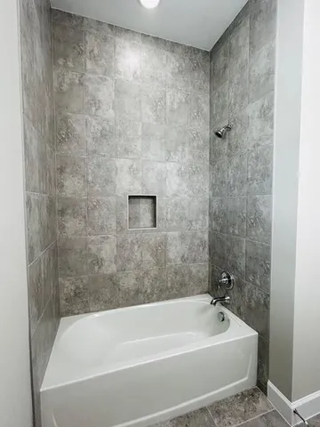 a bath tub sitting next to a white sink and a shower