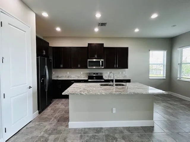 a view of a kitchen with a sink cabinets and refrigerator