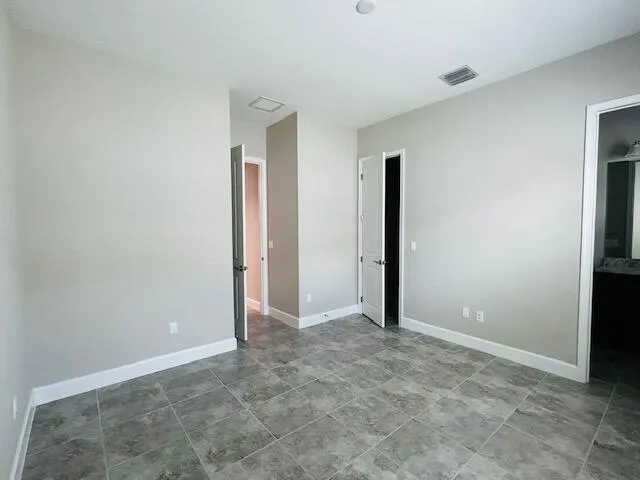 an empty room with closet and mirror