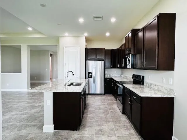 a kitchen with stainless steel appliances kitchen island granite countertop a sink counter space and cabinets