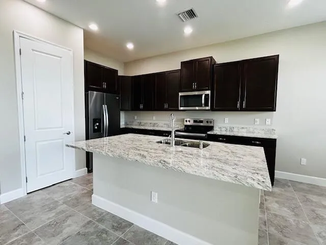 a kitchen with stainless steel appliances granite countertop a refrigerator stove microwave and sink