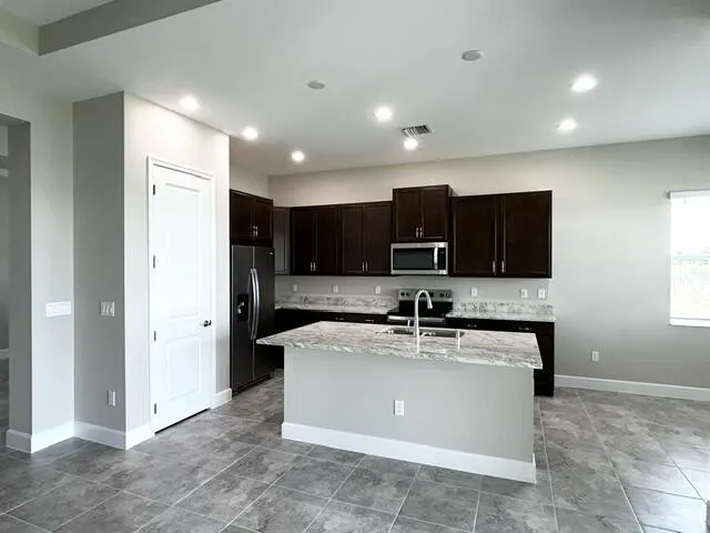 a kitchen with stainless steel appliances granite countertop a sink and a refrigerator