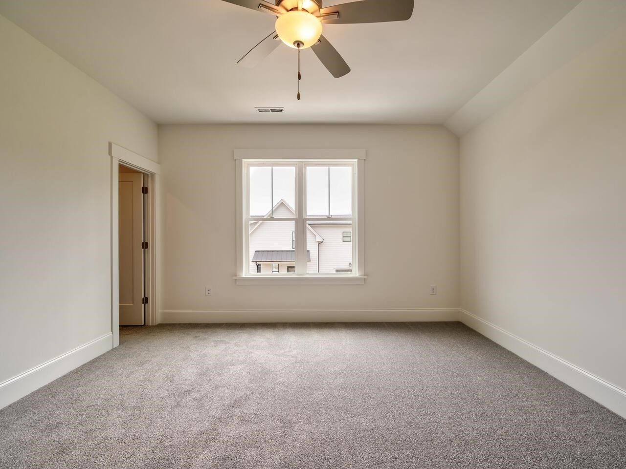 16 Constitution Avenue Smithfield, NC 27577 - Photo 38 of 60 an empty room with a chandelier fan and windows