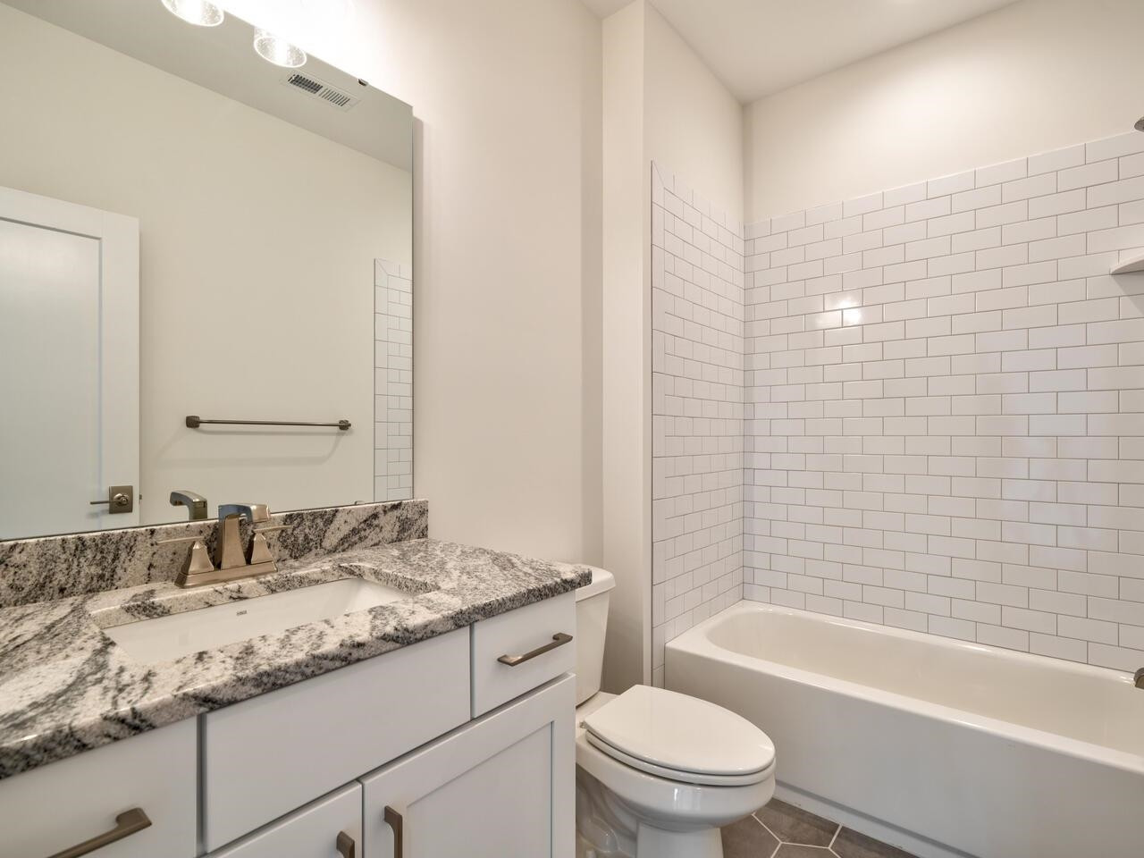 16 Constitution Avenue Smithfield, NC 27577 - Photo 39 of 60 a bathroom with a granite countertop toilet a sink and a bathtub
