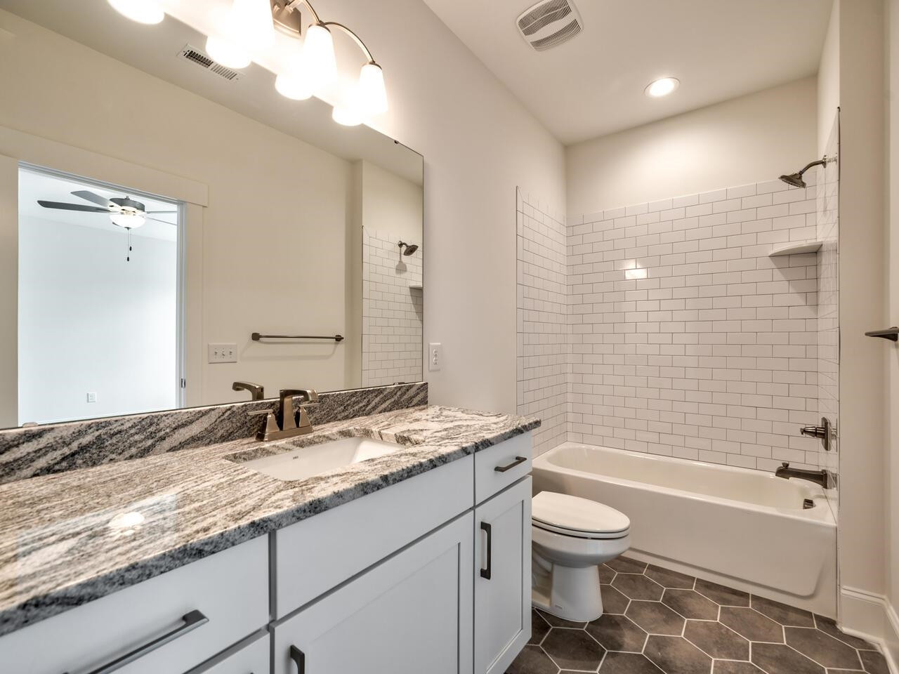 16 Constitution Avenue Smithfield, NC 27577 - Photo 42 of 60 a bathroom with a granite countertop toilet a sink and a bathtub