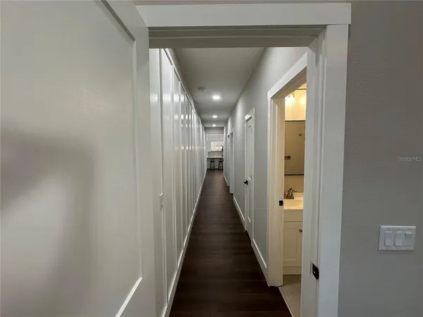 a view of a hallway with wooden floor and staircase