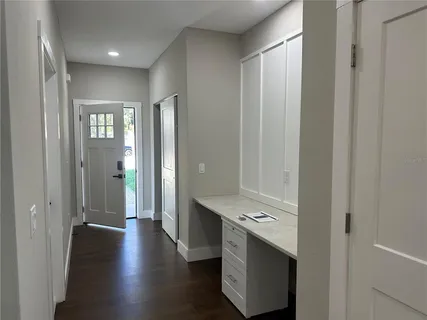 a view of a hallway with bathroom and wooden floor