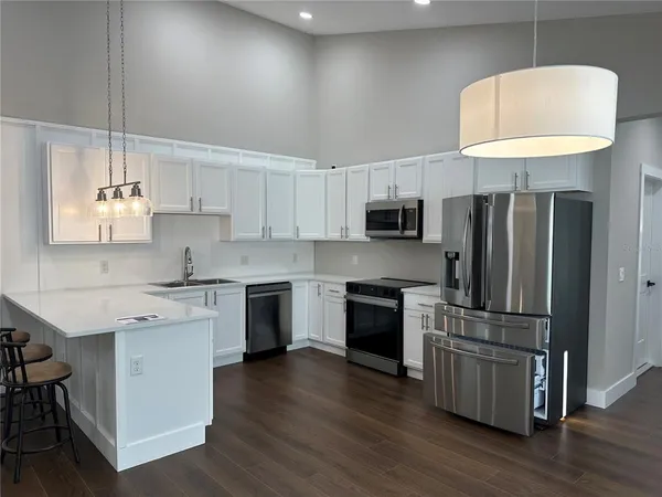 a kitchen with kitchen island granite countertop a sink a counter space stainless steel appliances and cabinets