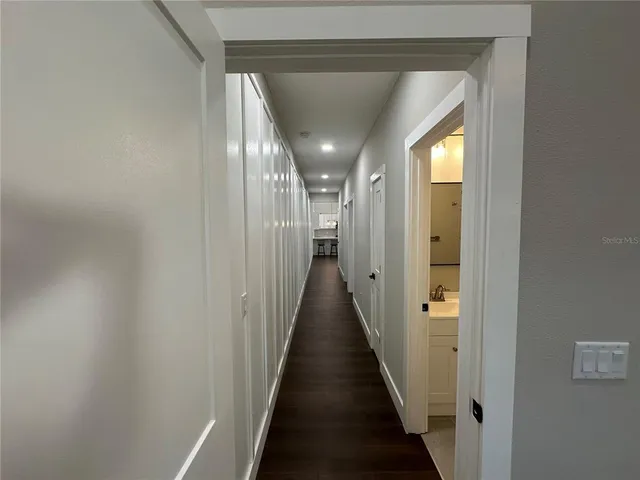 a view of a hallway with wooden floor and staircase
