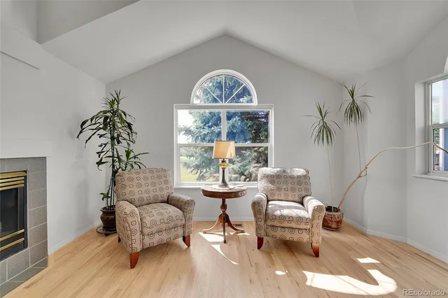 a dining room with furniture large windows and wooden floor
