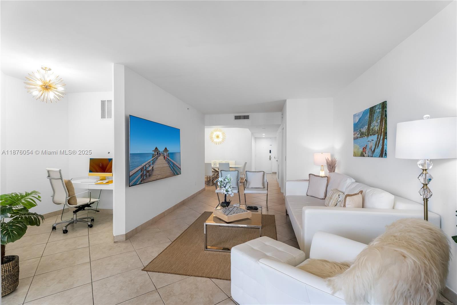 4779 Collins Avenue, Unit 1008 Miami Beach, FL 33140 - Photo 17 of 36 a living room with furniture and a flat screen tv