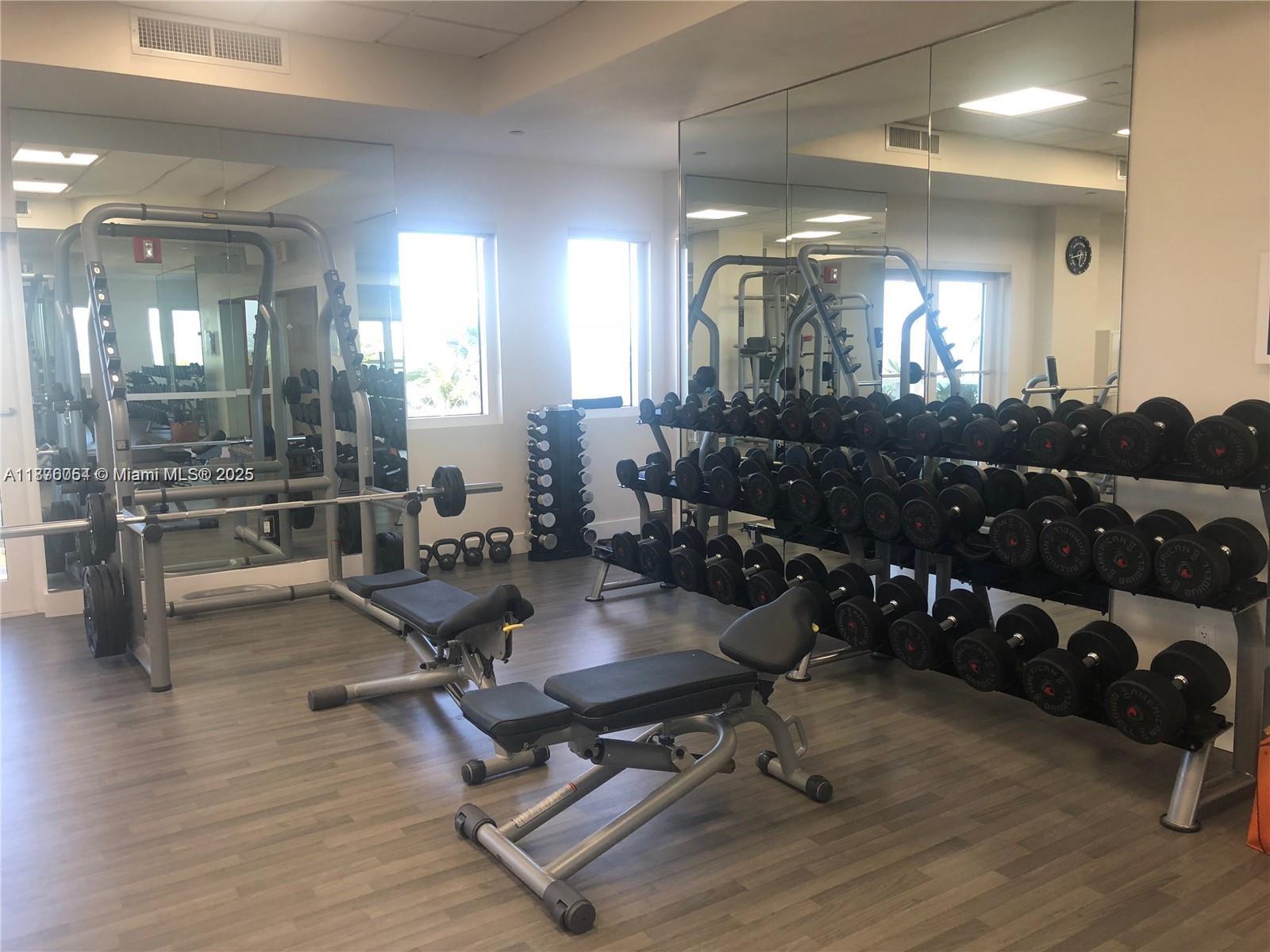 4779 Collins Avenue, Unit 1008 Miami Beach, FL 33140 - Photo 20 of 36 a room with lots of chairs and mirrors