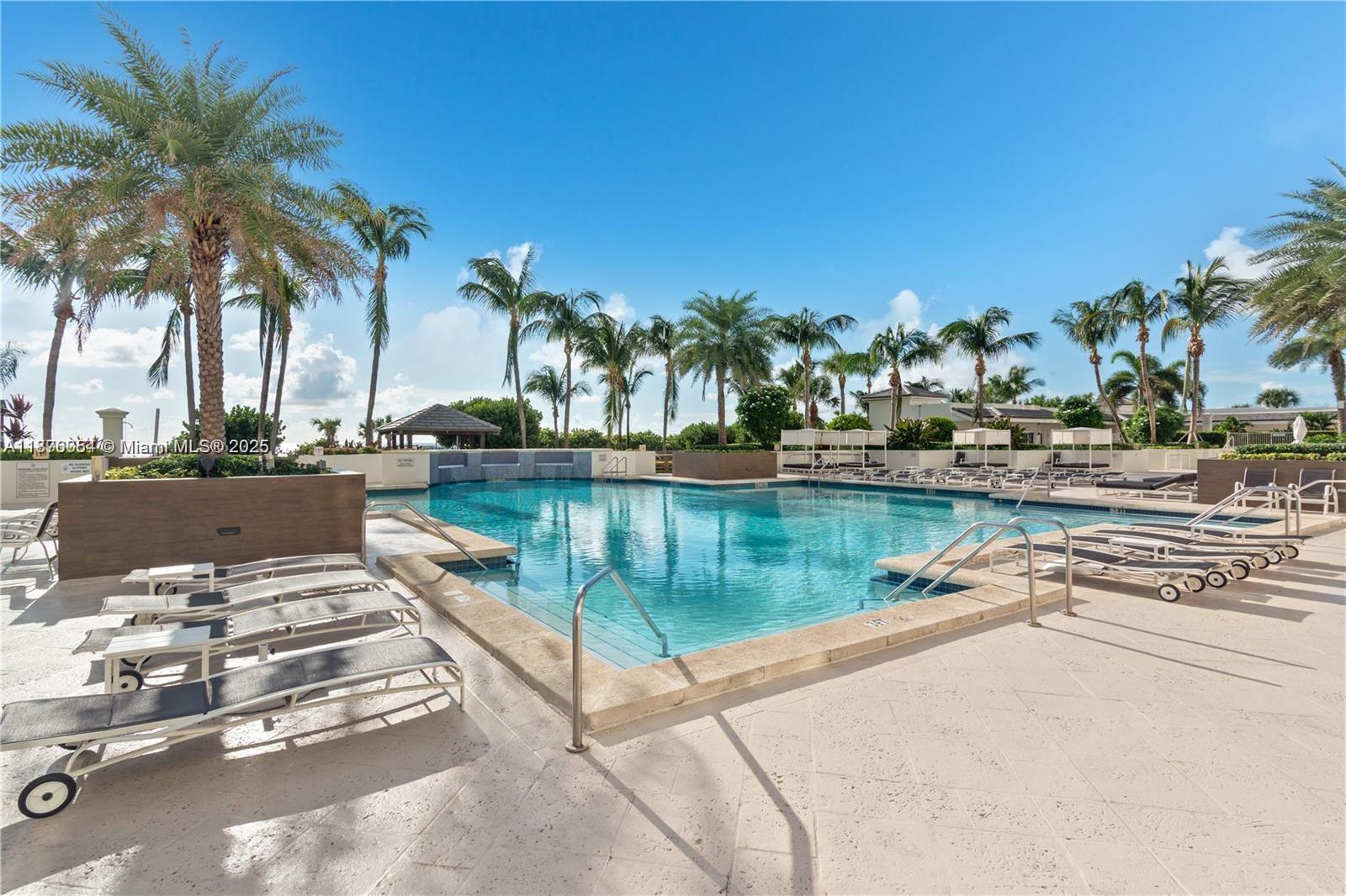 4779 Collins Avenue, Unit 1008 Miami Beach, FL 33140 - Photo 29 of 36 a view of swimming pool with a table and chairs