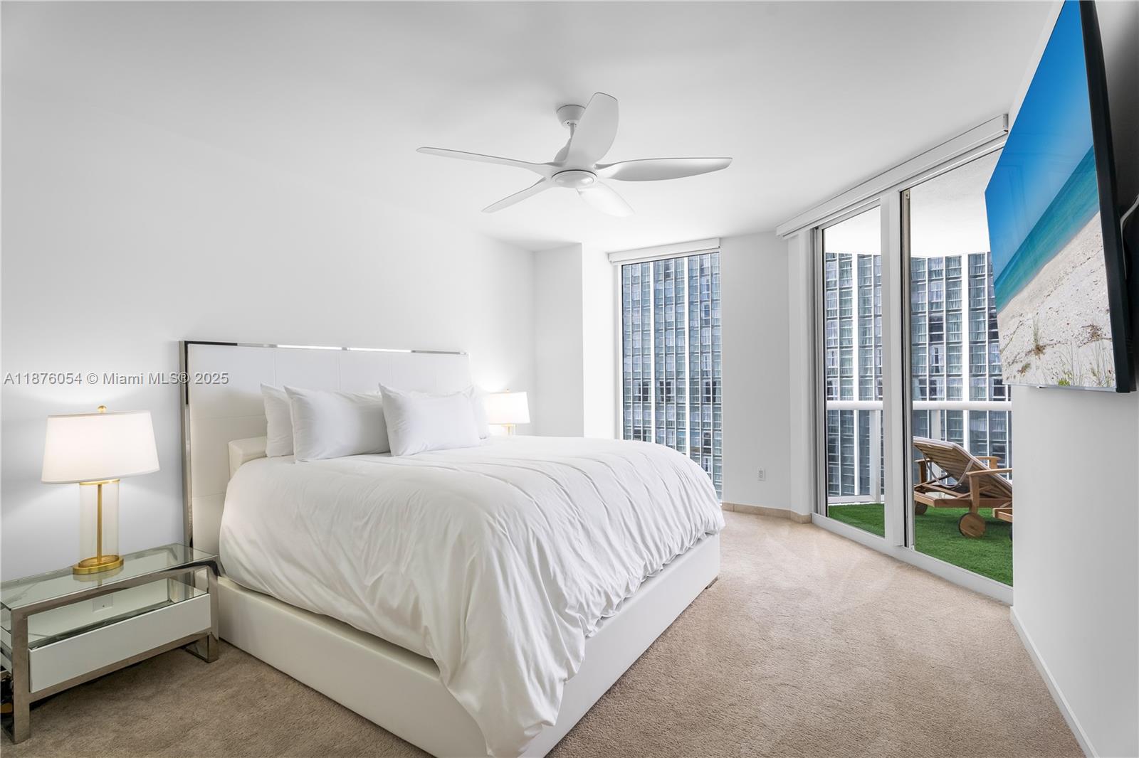 4779 Collins Avenue, Unit 1008 Miami Beach, FL 33140 - Photo 4 of 36 a spacious bedroom with a bed and a lamp