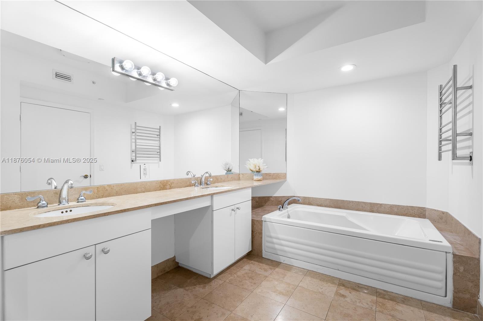 4779 Collins Avenue, Unit 1008 Miami Beach, FL 33140 - Photo 6 of 36 a spacious bathroom with a bathtub a double vanity sink and a mirror