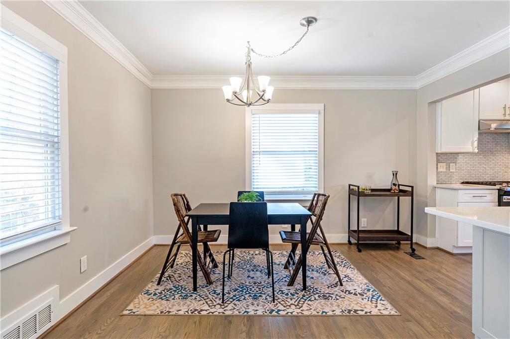 1403 Lavista Road Northeast Atlanta, GA 30324 - Photo 15 of 43 a dining room with wooden floor a chandelier a wooden table and chairs