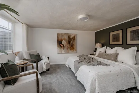 a bedroom with bed couches and flat screen tv