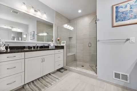 a spacious bathroom with a shower a sink and mirror