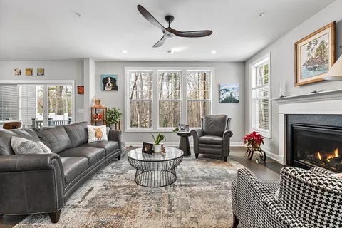 a living room with furniture fireplace and a large window