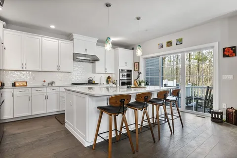 a kitchen with appliances cabinets and chair