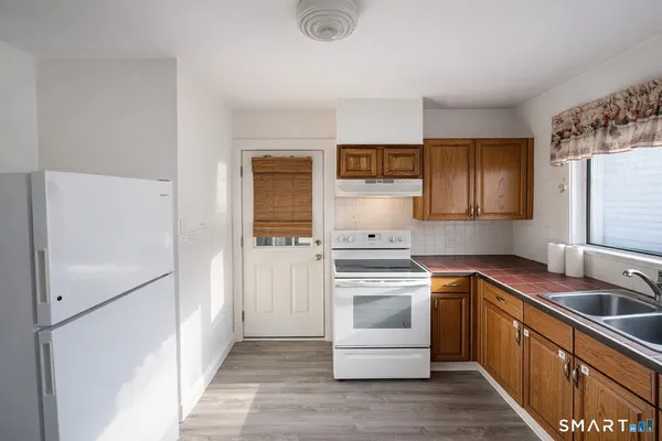 a kitchen with stainless steel appliances granite countertop a refrigerator sink and stove