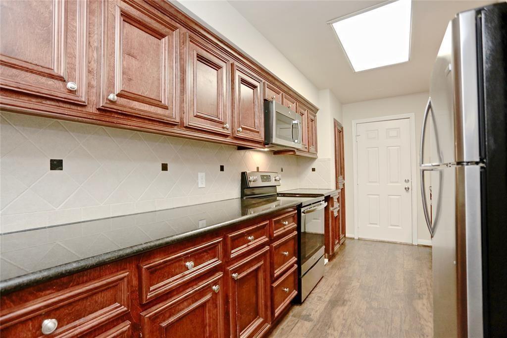 a kitchen with stainless steel appliances granite countertop a refrigerator and cabinets