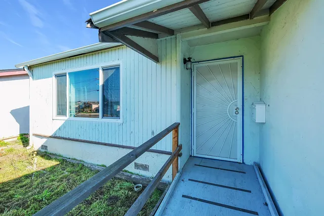 an empty room with wooden floor fireplace and windows