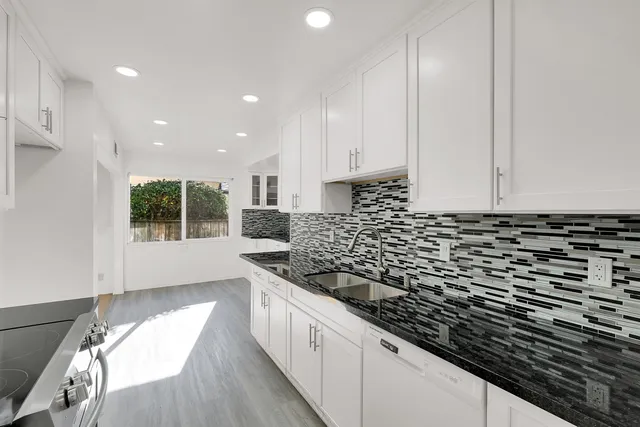 a kitchen with white cabinets and appliances