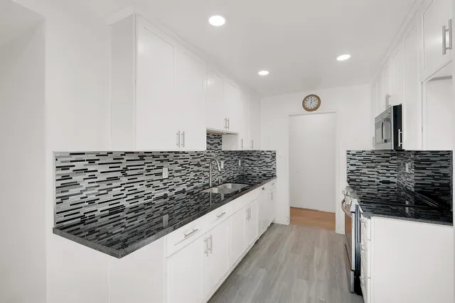 a kitchen with granite countertop white cabinets and white appliances