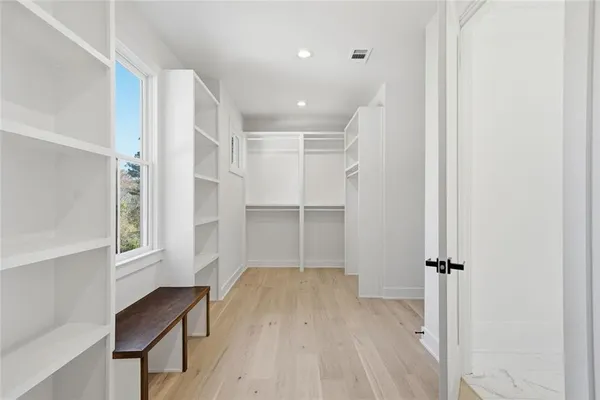 an empty room with wooden floor and ceiling fan