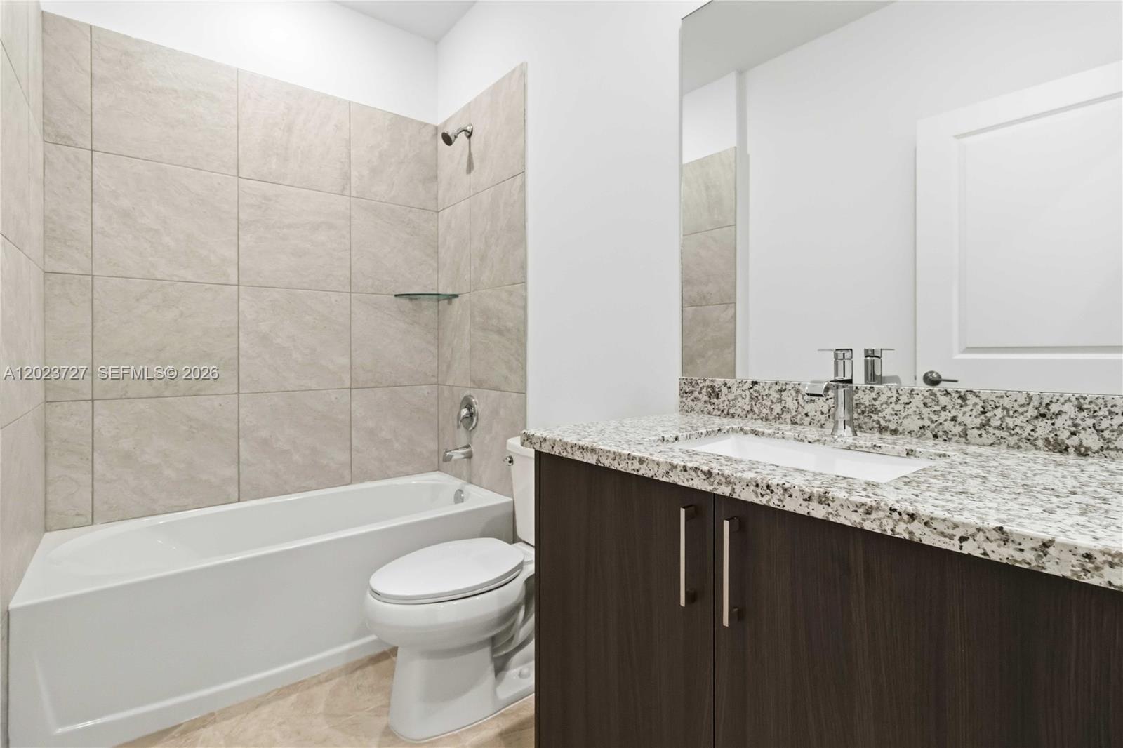 22348 Southwest 115th Court, Unit 22348 Miami, FL 33170 - Photo 32 of 37 a bathroom with a granite countertop bathtub sink vanity mirror and toilet
