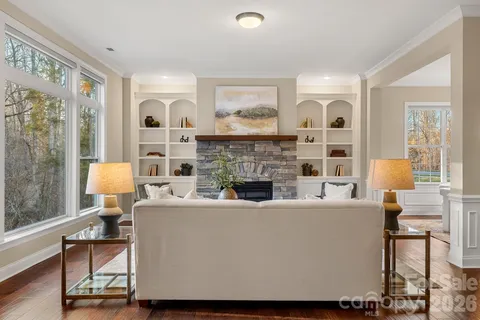 a living room with furniture a fireplace and a large window