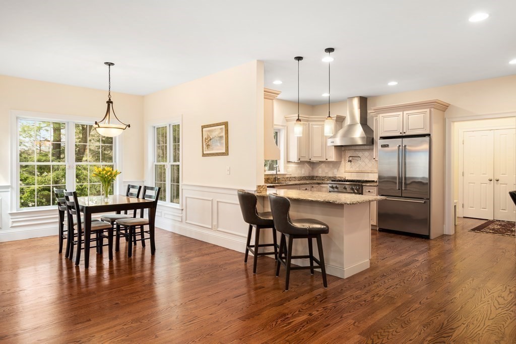 11 Shadow Lane Wellesley, MA 02482 - Photo 11 of 37 a kitchen with stainless steel appliances granite countertop a stove a refrigerator a kitchen island a dining table and chairs with wooden floor
